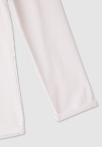 Białe spodnie z tkaniny o gładkiej fakturze, z prostą nogawką i starannie podwiniętymi mankietami przy kostkach.