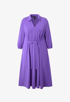 Lilla knælængde kjole med trekvartærmer, V-hals og et matchende stofbælte bundet om taljen.