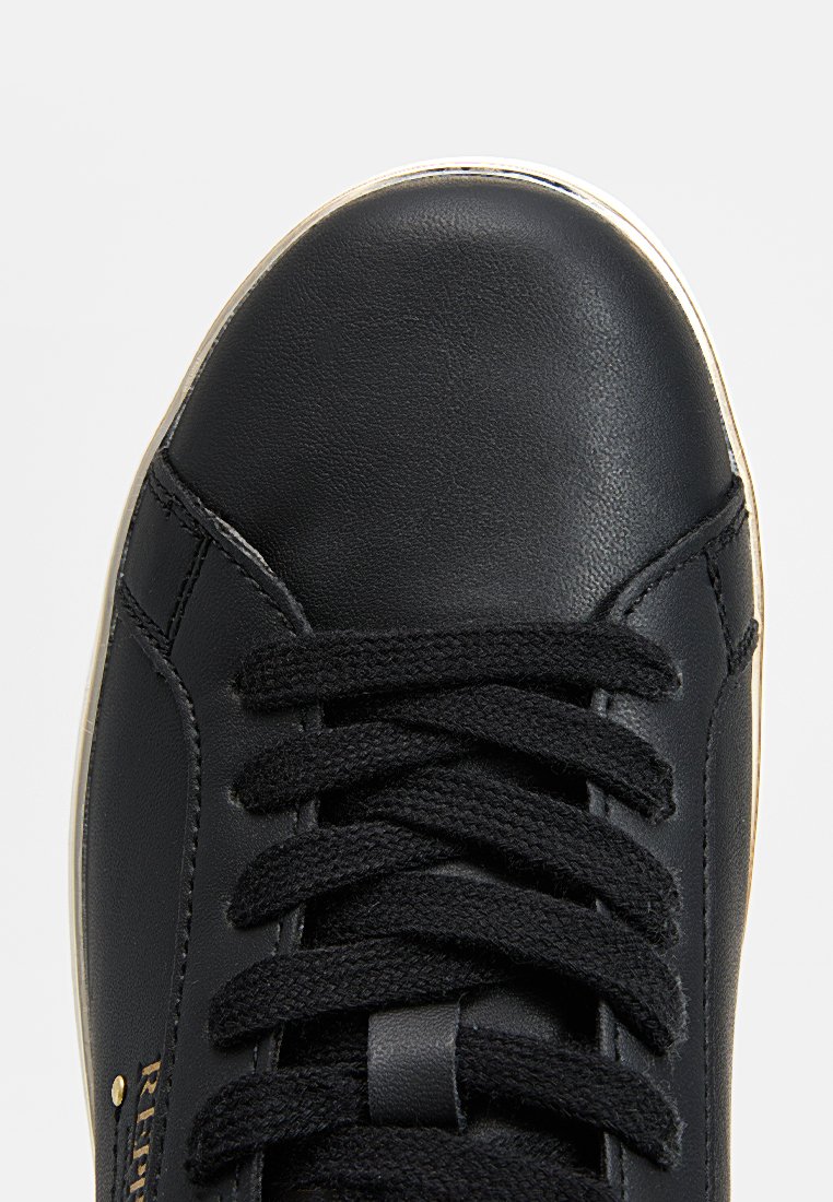 Baskets en cuir noir avec lacets noirs et semelle blanche, vues du dessus en se concentrant sur la partie avant et les lacets.