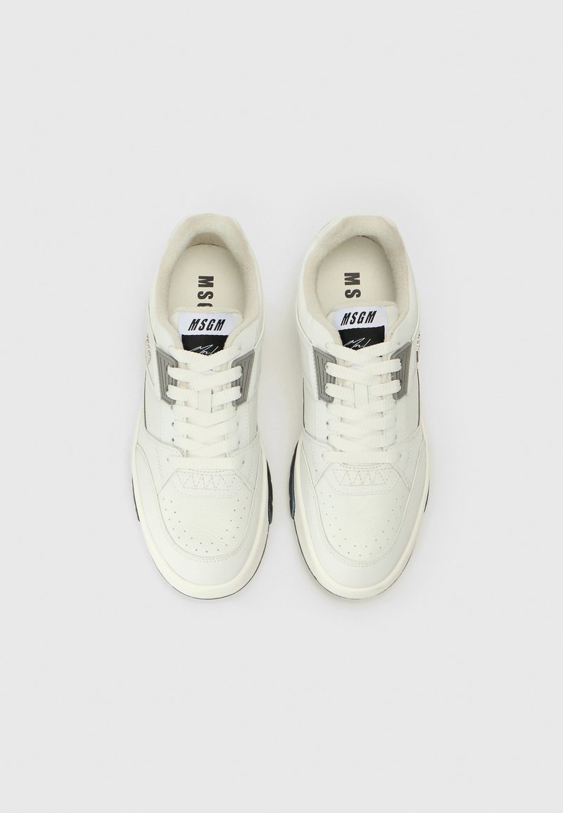 Weiße Leder-Sneaker mit perforiertem Zehenbereich, grauen Akzenten und einem schwarzen Logoetikett auf der Zunge. Verfügt über eine Schnürung und eine Gummisohle.