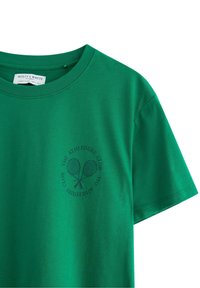Grøn bomulds T-shirt med rund halsudskæring og korte ærmer, udsmykket med et trykt tennisracket-design og tekst.