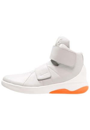 Wysokie białe skórzane sneakersy z podwójnymi paskami na rzep i pomarańczowym akcentem na podeszwie, widok z boku.