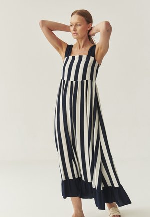 Maxikleid mit navyblauen und weißen Streifen, quadratischem Ausschnitt, breiten Trägern und einem Rüschensaum. Aus leichtem Stoff für einen hohen Tragekomfort gefertigt.