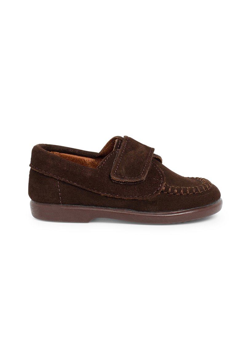 Scarpa mocassino in suede marrone con punta arrotondata, cinturino in Velcro singolo e cuciture decorative lungo il bordo. Suola in gomma bassa per il comfort.