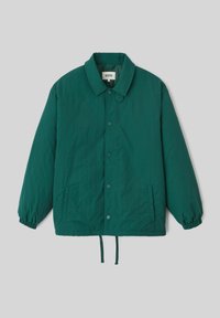 Veste légère verte avec un col, des boutons-pression, des poignets élastiques, des poches latérales et un ourlet ajustable avec cordon.