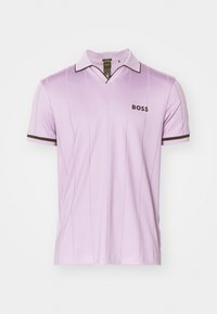 Levandos spalvos polo marškiniai, pagaminti iš lygaus audinio, su klasikinėmis apykaklėmis, tamsiomis juostelėmis ant rankovių ir logotipu krūtinėje.