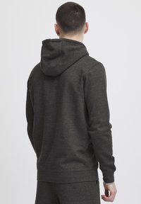 Donkergrijze hoodie met een zachte textuur, lange mouwen en een kangoeroezak; minimalistisch ontwerp zonder zichtbare patronen of hardware.
