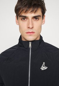Jordan WARMUP - Casaco de verão - black