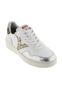 Sneaker bianco con punta metallica argento, dettagli in glitter oro e tallone con stampa leopardata. Design con lacci e punta perforata per la traspirabilità.