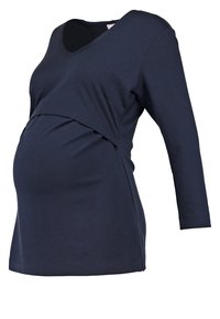 Těhotenský top v námořnické modři s výstřihem do V, dlouhými rukávy a překrývajícím se předním designem. Vyrobeno z měkké, elastické tkaniny pro pohodlí a dobré padnutí.