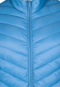 Gilet imbottito azzurro chiaro con colletto alto, caratterizzato da cuciture a chevron e una chiusura con zip frontale. Finitura liscia e lucida.
