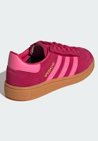 Rosa semskede sneakers med rosa skinnakenter, tre rosa side-striper, en gummirubber såle, og gull "SPEZIAL" merke på hælen.