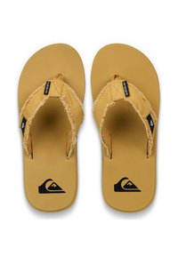 Gula flip-flops med texturerade remmar och en slät sula. Har en svart logotypaccent på varje fotbädd och fransade detaljer på remmarna.
