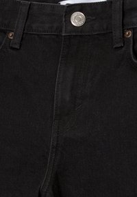 Zwarte denim jeans hebben een klassieke vijf-pocket ontwerp met een zilverkleurige metalen knoop en verstevigde stiksel langs de naden.