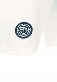 Ein weißer Stoff mit einem kreisförmigen marineblauen Logo mit einem Gesichtsmotiv, das sich im unteren Bereich des Kleidungsstücks nahe dem Saum befindet.