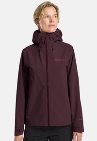 Giacca impermeabile color amaranto con cappuccio aderente, zip frontale completa e polsini regolabili. Presenta il logo sul lato sinistro del petto e una texture liscia.