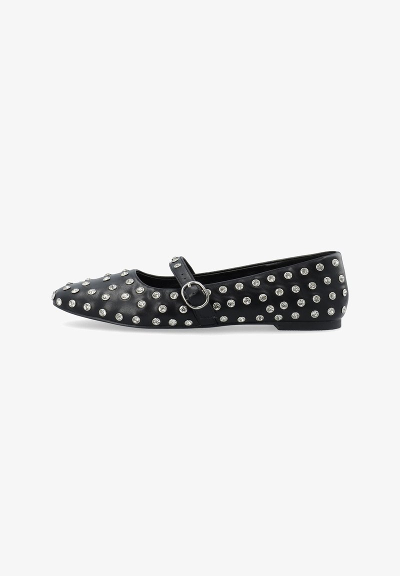 Chaussure plate noire avec un bout rond, ornée de clous en argent, et une sangle à la cheville avec une boucle en métal. Texture lisse, talon bas.