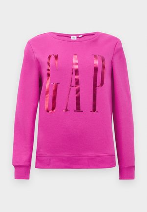 Rosa sweatshirt med ordet "GAP" i reflekterende materiale, rund halslinje og lange ermer. Glatt tekstur med ribbede mansjetter.