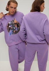 Paarse sweatshirts en bijpassende broeken van zacht materiaal, met een grafisch Avengers-logo op de voorkant. Casual, relaxte pasvorm, met broek met trekkoord.