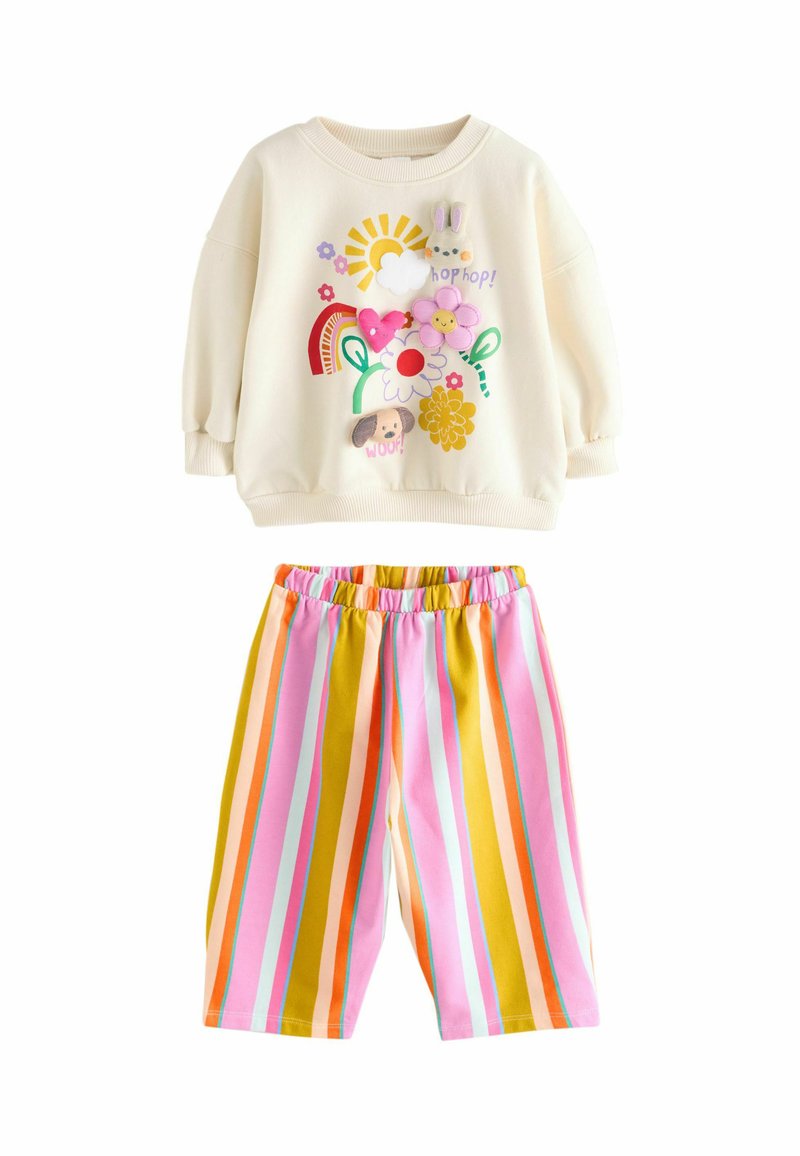 Sweat-shirt couleur crème avec graphiques colorés ; short rayé à taille élastique en rose, jaune et teintes pastel. Matériau en coton doux.
