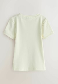 Camiseta de manga corta de color amarillo claro con textura acanalada, escote redondeado y dobladillo ligeramente curvado. Diseño sencillo sin adornos.