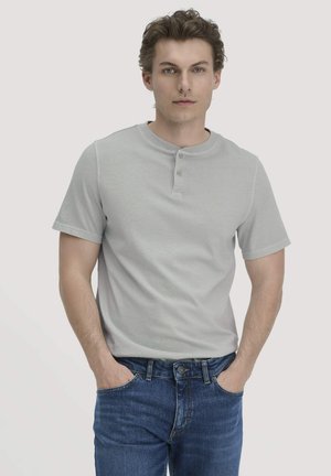 Lichtgrijze korte mouwen henley shirt met een ronde halslijn, placket met twee knopen en een gladde textuur, gecombineerd met blauwe jeans.