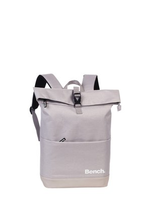 Light gray Bench backpack with roll-top closure, front pocket, adjustable shoulder straps, and black buckle on a white background.