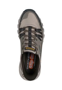 Scarpa sportiva grigia senza lacci con tomaia in mesh, strisce nere a contrasto e suola strutturata. Presenta il logo "SKECHERS" e una soletta in memory foam.
