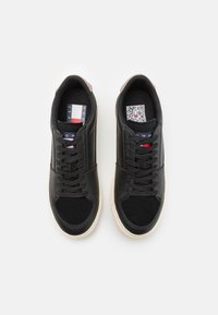 Zapatillas negras fabricadas en cuero y ante, con un diseño con cordones, suela de goma beige en contraste y acentos de logo en la lengüeta.