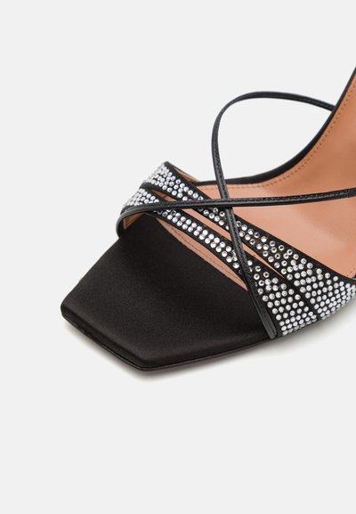 Black satin heeled sandal with a square toe, featuring crisscross straps adorned with silver rhinestones for added detail.