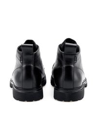 Zwarte leren enkelboots met een textuurafwerking, stevige rubberen zolen en achterste treklussen voor gemakkelijk aan- en uittrekken. Ontworpen voor duurzaamheid en comfort.