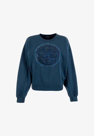 Sudadera azul marino con cuello redondo, mangas con caída y dobladillo acanalado. Presenta un logo circular texturizado con elementos metálicos en la parte delantera.
