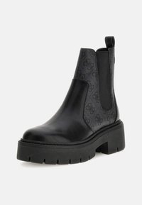 Stivaletti Chelsea neri con tomaia in pelle liscia, pannelli laterali texture e suola piatta chunky. Presentano inserti elasticizzati e un tassello per la presa.