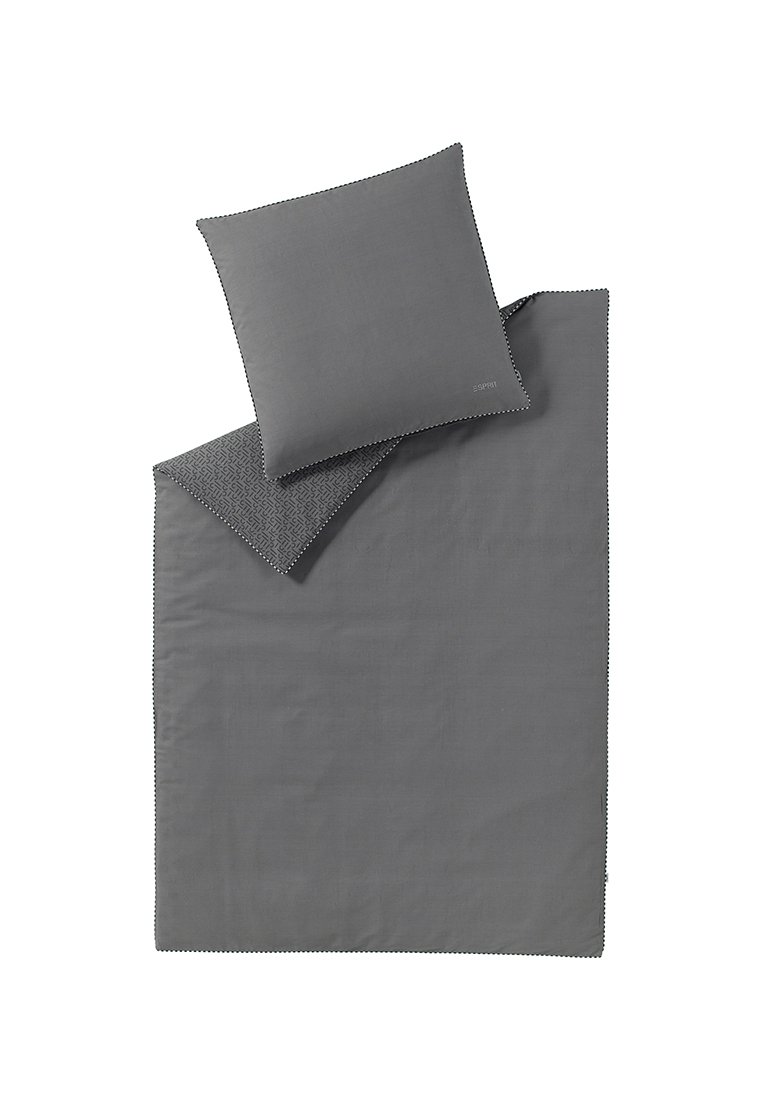 Ensemble coussin et couverture gris foncé, avec le coussin retourné pour montrer un design géométrique à motifs d'un côté.