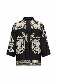 Chemise noire avec imprimé floral crème, dotée d'un col et de manches trois-quarts. Comprend des motifs détaillés le long de l'ourlet. Texture de tissu douce.