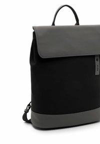 Sac à dos noir en matériau synthétique lisse avec un rabat gris, une poignée supérieure, des bretelles ajustables et un accent gris en bas.