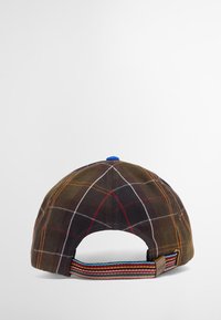 Καφέ καπέλο με καρό σχέδιο και καμπυλωτό γείσο, μπλε κουμπί στην κορυφή και ρυθμιζόμενος ιμάντας με πολύχρωμο σχέδιο στο πίσω μέρος.