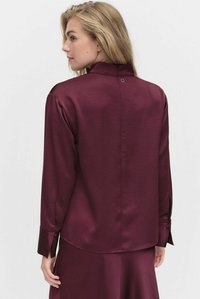Bordowa satynowa koszula z wysokim kołnierzem, długimi rękawami i mankietami na guziki. Zapięcie na guziki z tyłu oraz gładka, błyszcząca faktura.