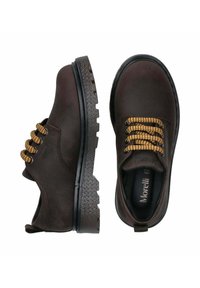 Bruine suède schoenen met een robuuste zwarte rubberen zool en crèmekleurige veters. Voorzien van een ronde neus en een minimale branding op de binnenzool.