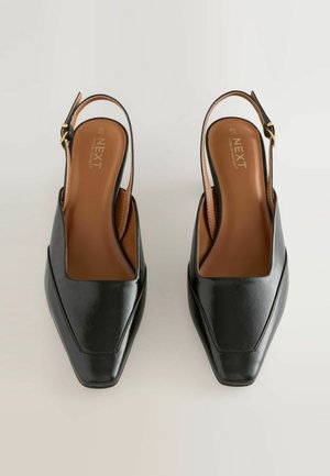 Čierne kožené slingback podpätky so štvorcovou špičkou a hladkým povrchom. Obsahuje hnedú stielku a zlatý prackový uzáver na remienku okolo členka.