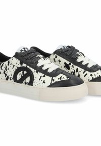 Black and white sneakers with a splatter pattern, featuring a black accent at the toe and logo, white laces, and a white rubber sole.
