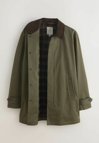 Manteau homme vert olive avec col en velours côtelé marron foncé, fermeture par boutons, poches latérales et doublure intérieure à carreaux foncés.