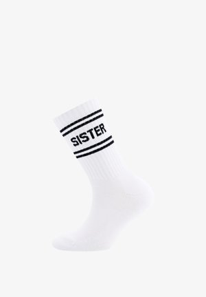 Chaussette en coton blanc avec une texture côtelée, ornée de rayures noires et du mot "SŒUR" en lettres majuscules autour de l'ourlet.