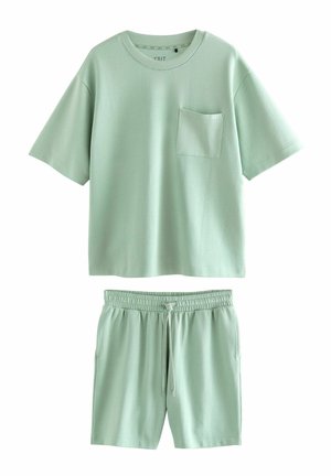 Ensemble de détente vert clair comprenant un T-shirt à manches courtes avec une poche sur la poitrine et un short assorti à taille élastique. Texture de tissu douce.