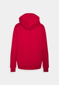 Felpa rossa con tessuto morbido e strutturato, dotata di un ampio cappuccio e polsini e orlo a costine per una vestibilità aderente. Dietro liscia senza grafiche.