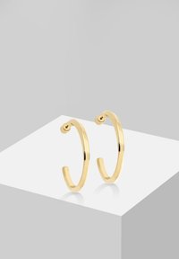 Gouden creolen met een slank, circulair ontwerp. Gemaakt van metaal, met een gepolijste afwerking en open uiteinden voor een gemakkelijke draagervaring.