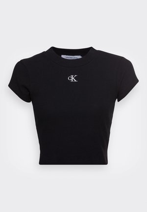 Black cropped t-shirt made from ribbed fabric, featuring short sleeves and a round neckline. White embroidered "ck" logo on the chest.