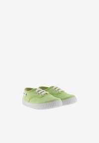 Zapatos de lona verdes con suelas de goma blanca, con cordones y costuras blancas, punta redondeada y una pequeña etiqueta de la marca en el lado.