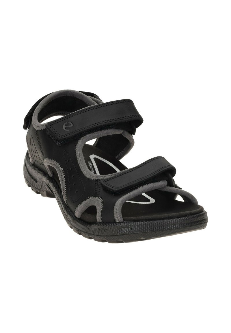 Sandales noires avec des accents gris, dotées d'un bout fermé, de sangles réglables en Velcro, de découpes respirantes et d'une semelle en caoutchouc texturé.