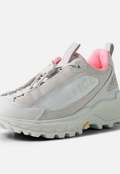 Baskets gris clair et blanches avec semelle épaisse, lacets élastiques bungee, doublure intérieure rose et logo "FIRE + ICE" sur le panneau latéral.